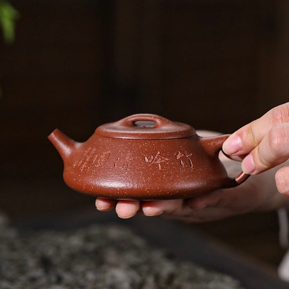 Handheld side shot of Master Ding Hongbin handmade Yixing Shipiao Zisha teapot, silky warm jade clay vintage literati tea craft for high-end collectors SONGKILN