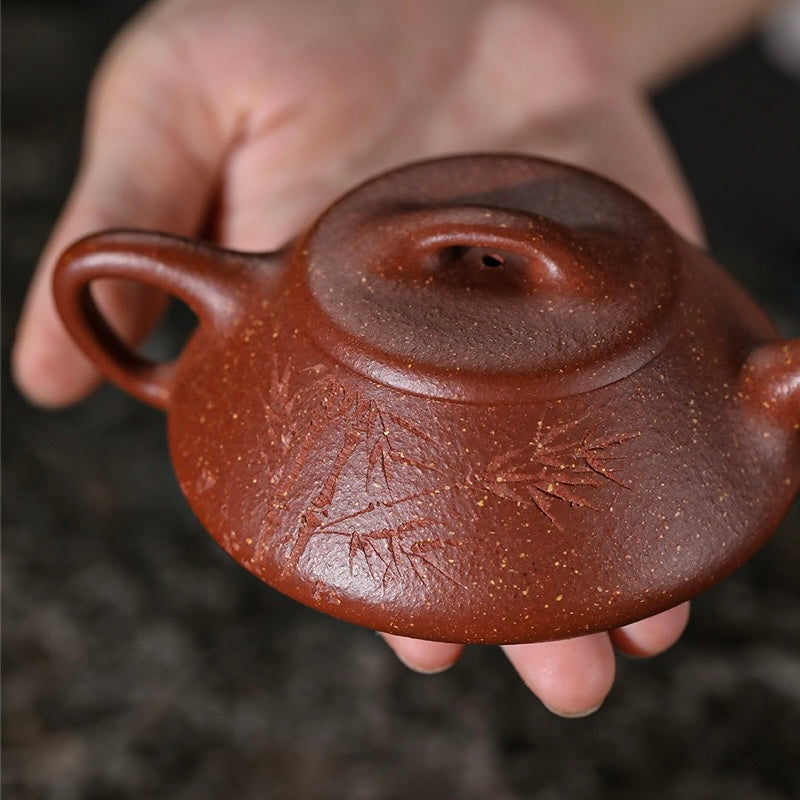 Macro close-up of intricate manual carving texture on collector-grade Yixing Shipiao Zisha teapot, zero-mold handmade warm jade clay craft SONGKILN