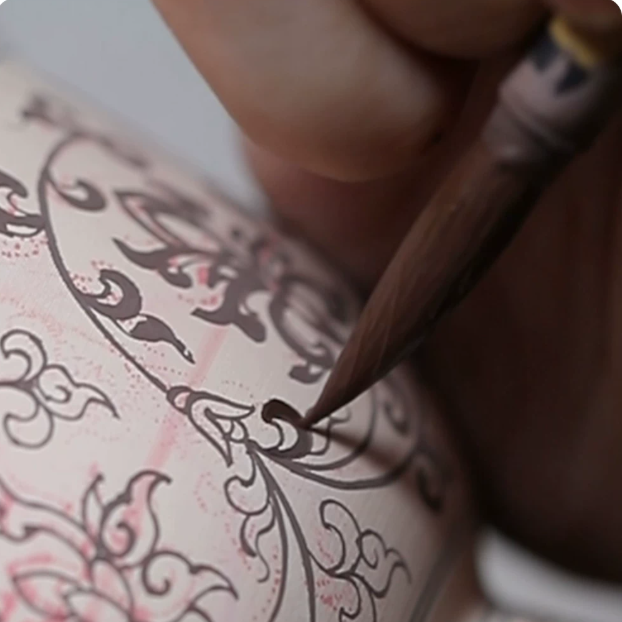 Artist hand-painting underglaze blue floral pattern on SONGKILN porcelain tea ware, close-up of traditional Jingdezhen brushwork and ceramic craft process